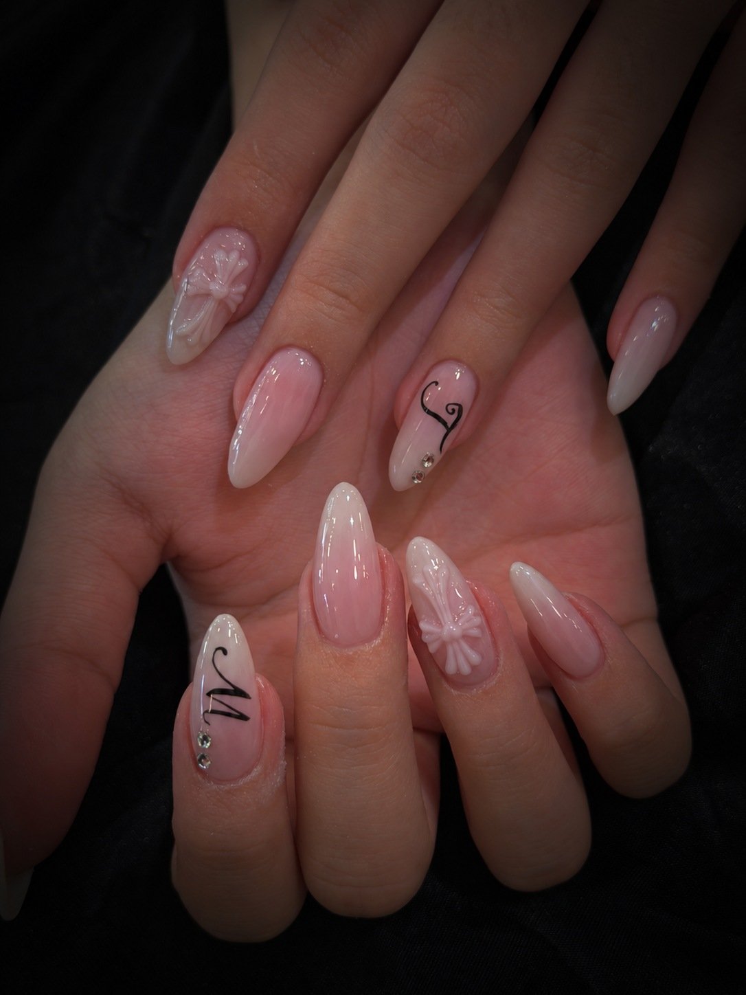 Pink almond nails with sculpted bows, lettering and crystal details at Stanley Nails Highgate