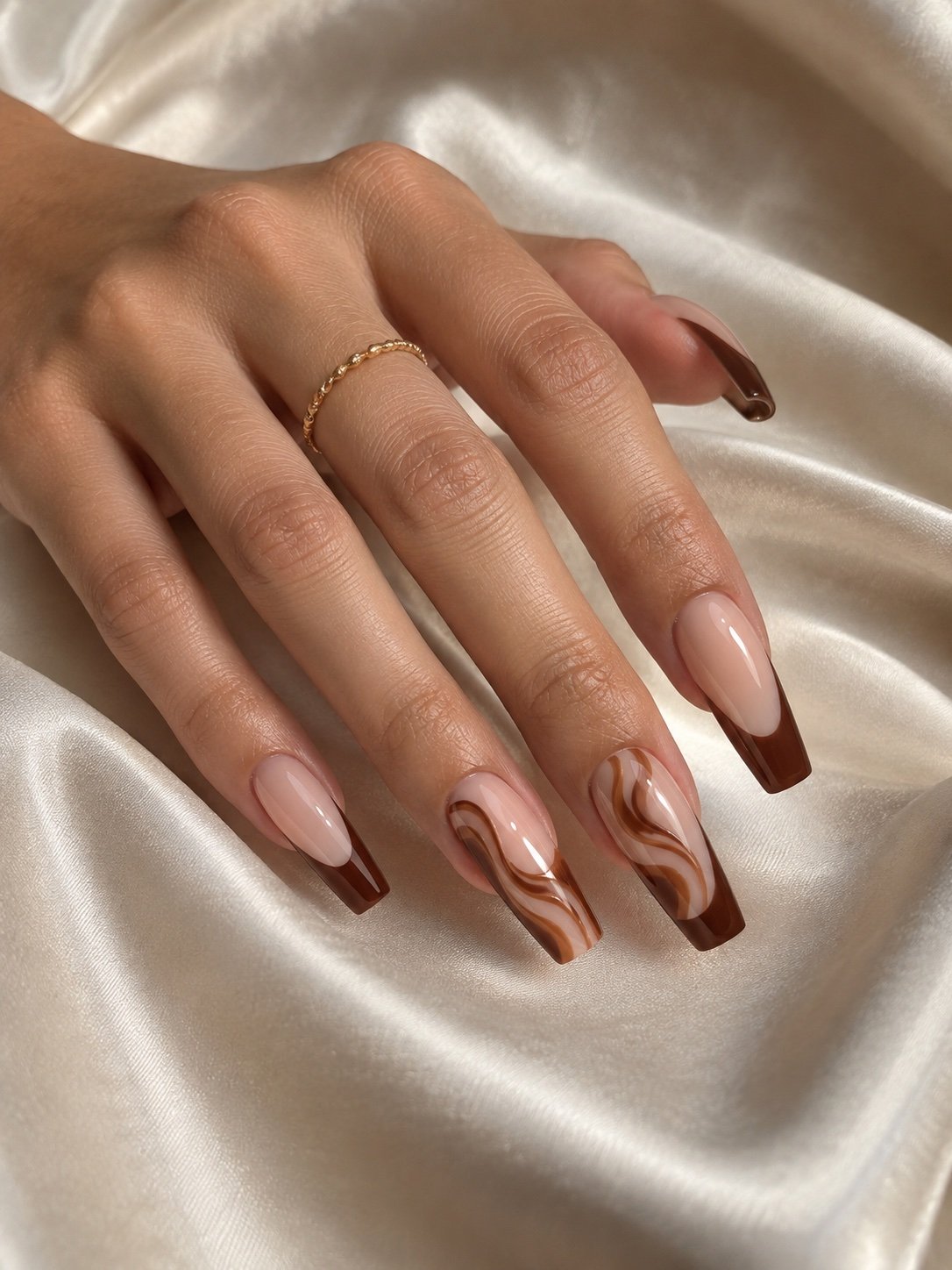 Long coffin nails with chocolate French tips and caramel swirl nail art